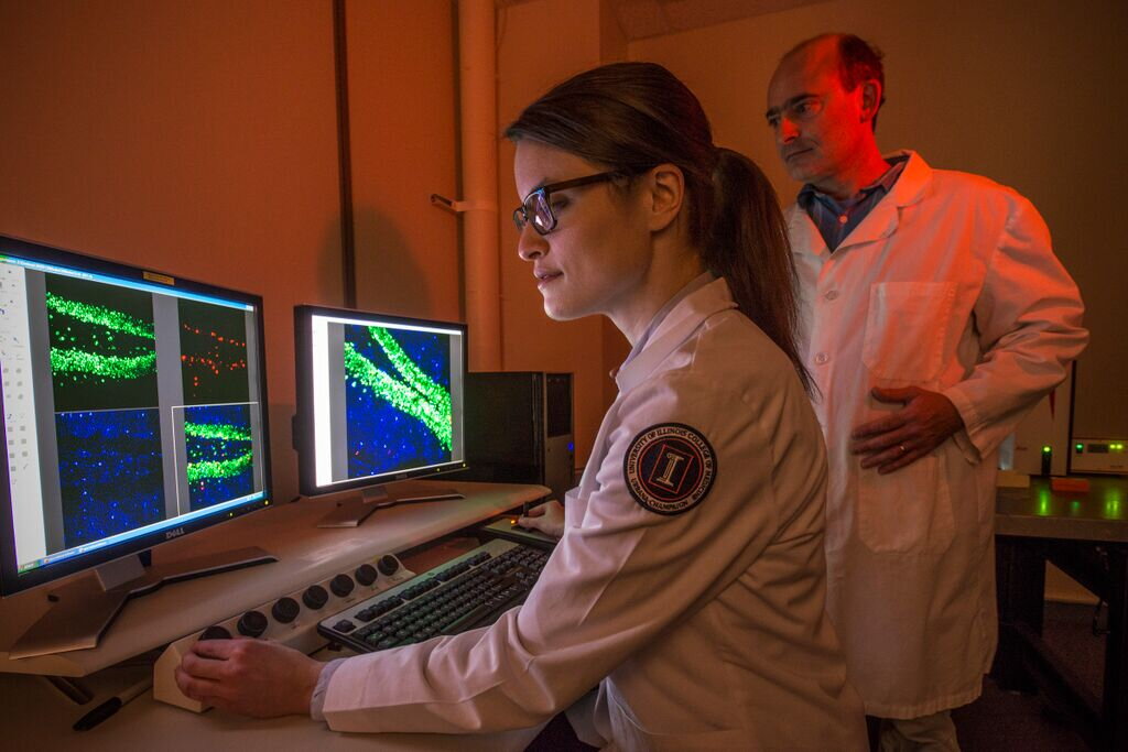 student and teacher looking at data on a computer