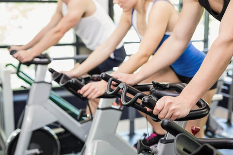 Fit group of people using exercise bike together