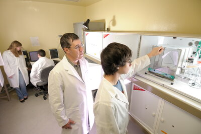student and teacher using lab equpment