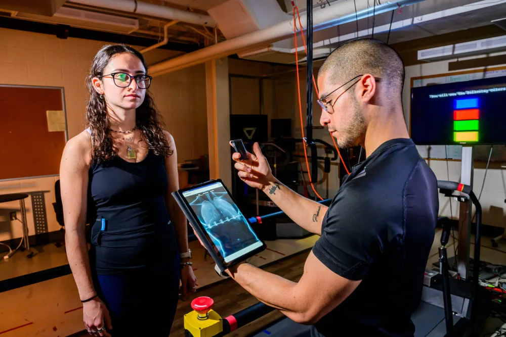 Graduate student Jonathan Cerna monitors heart data from a “smart shirt” that tracks electrical activity as graduate student Laila Shaaban exercises and rests. Researchers are working to develop the technology to make heart-related predictions more widely accessible through the use of wearables.