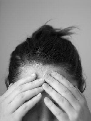 Woman in Distress Touching Forehead